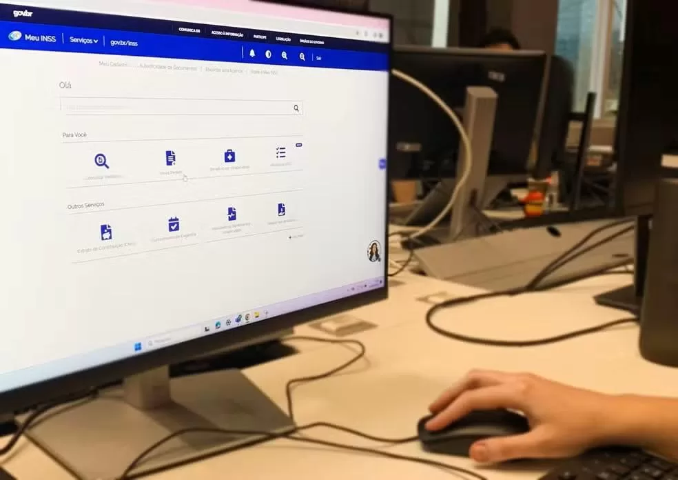 Advogado previdenciário mostrando a um segurado a simulação da aposentadoria ideal no computador.